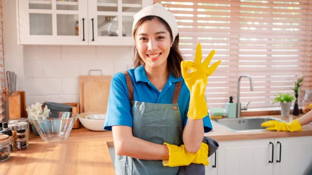 Deep cleaning technician standing in a tidy kitchen after completing household cleaning tasks.